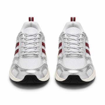 A pair of white and metallic silver running shoes with red side stripes and a black outsole, shown from a front-facing perspective on a white background.