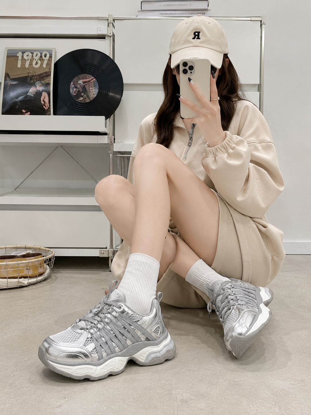 A pair of metallic silver athletic sneakers shown from the front on a clean white background.