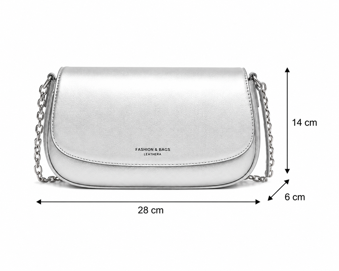 A silver metallic leather shoulder bag with a curved flap and a silver chain strap, featuring the text 'FASHION & BAGS LEATHERA' on the front, set against a plain white background.
