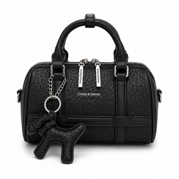 Front view of a black mini Boston handbag with textured leather, dual top handles, silver hardware, and a matching black dog charm, photographed in a professional studio on a clean white background.