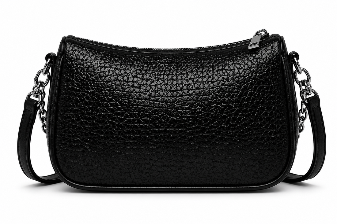 Front view of a black textured shoulder bag with silver chain accents and a curved silhouette, photographed in a professional studio on a clean white background.