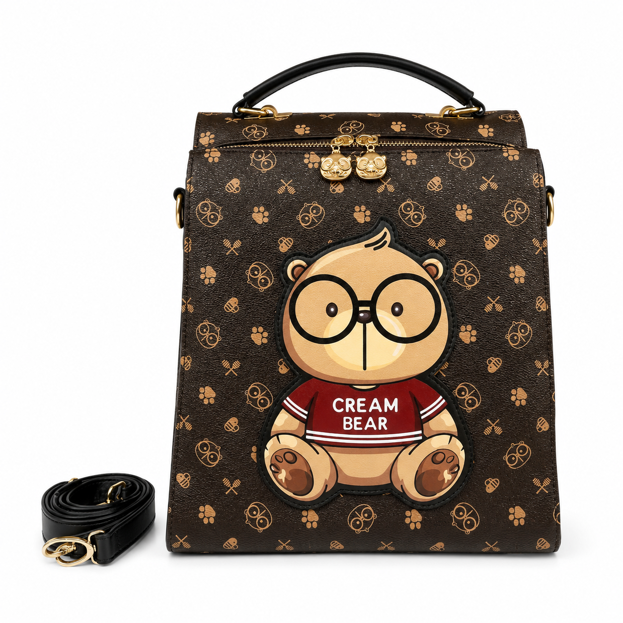 Brown cartoon bear square backpack with Cream Bear graphic, printed pattern, top handle, and detachable shoulder strap on a white studio background.