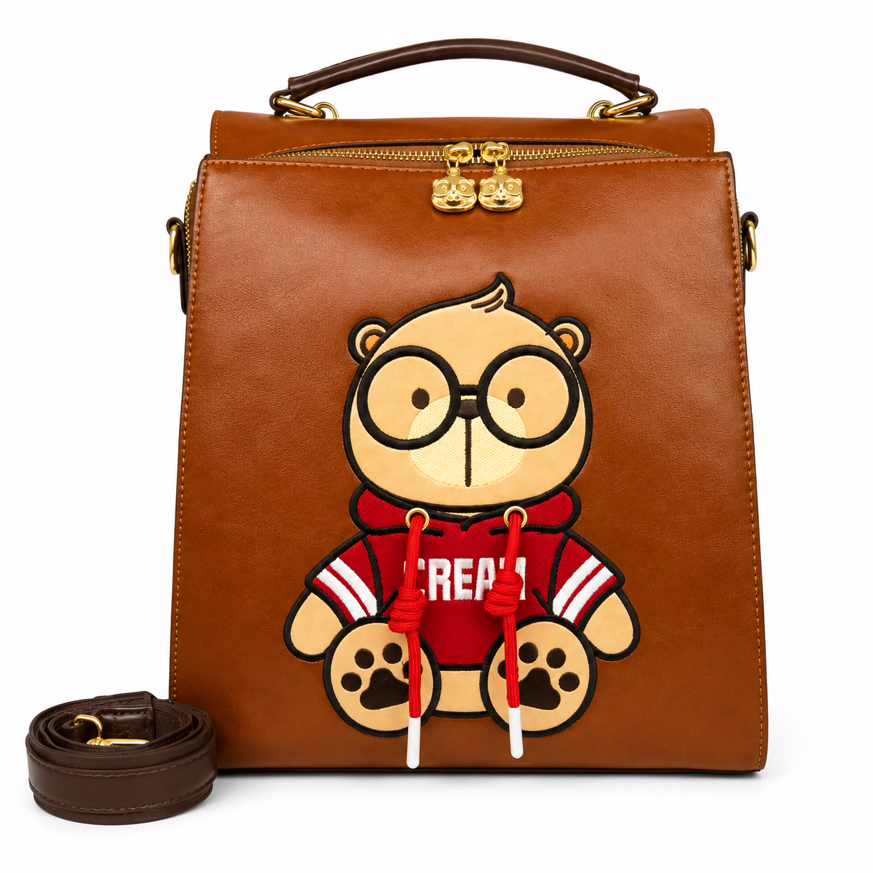 Brown Cream Bear square backpack with a cartoon bear in a red hoodie, top handle, gold-tone hardware, and detachable shoulder strap.