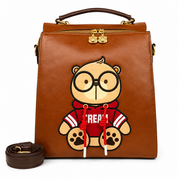 Brown Cream Bear square backpack with a cartoon bear in a red hoodie, top handle, gold-tone hardware, and detachable shoulder strap.