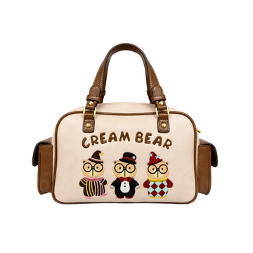 Beige Cream Bear Boston handbag with embroidered cartoon bear characters, brown handles, side pockets, and white studio background.