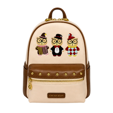 Beige Cream Bear mini backpack with three embroidered cartoon bears, brown trim, gold hardware, front zip pocket, and white studio background.