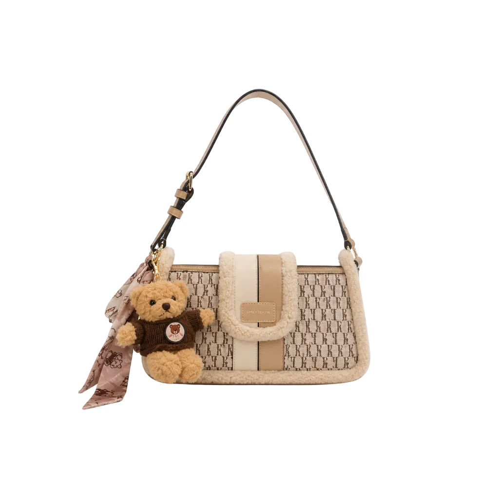 EMILY LORAN beige monogram shoulder bag with soft sherpa trim, adjustable shoulder strap, gold-tone hardware, and decorative teddy bear charm for everyday fashion.