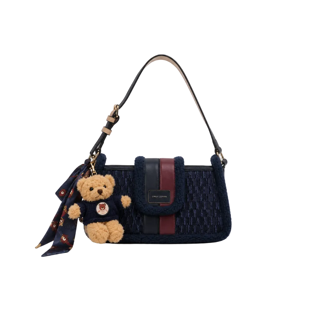 EMILY LORAN navy blue monogram shoulder bag with soft sherpa trim, adjustable shoulder strap, gold-tone hardware, and decorative teddy bear charm for everyday fashion.