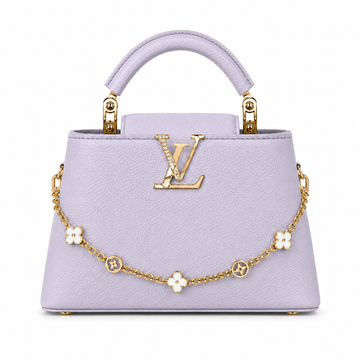 Louis Vuitton Capucines large lavender leather handbag with pearl-detailed gold LV logo, floral gold charm chain, structured top handle, and luxury designer styling.