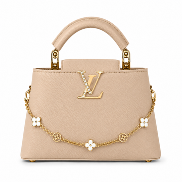 Louis Vuitton Capucines medium beige leather handbag with pearl-detailed gold LV logo, floral gold charm chain, structured top handle, and luxury designer styling