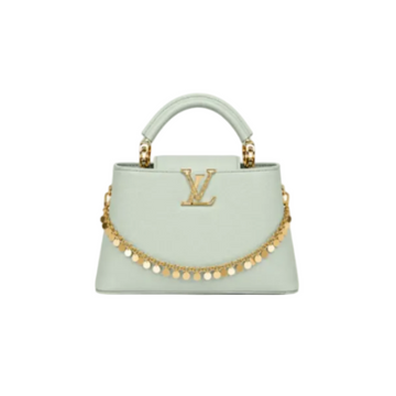 Louis Vuitton Capucines medium mint leather handbag with gold LV logo, decorative gold charm chain, structured top handle, and luxury designer style.