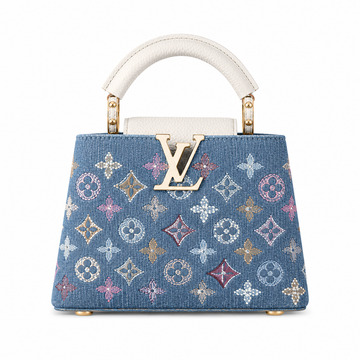 Louis Vuitton Capucines small blue denim monogram handbag with white leather top handle, gold LV logo, and structured luxury design.