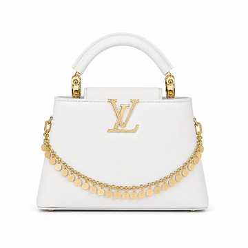 Louis Vuitton Capucines small white leather handbag with gold LV logo, decorative gold charm chain, structured top handle, and elegant luxury designer style.