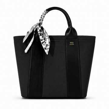 MISS ALITA black canvas tote handbag with leather trim, decorative black and white silk scarf handle, and structured design on a white background.