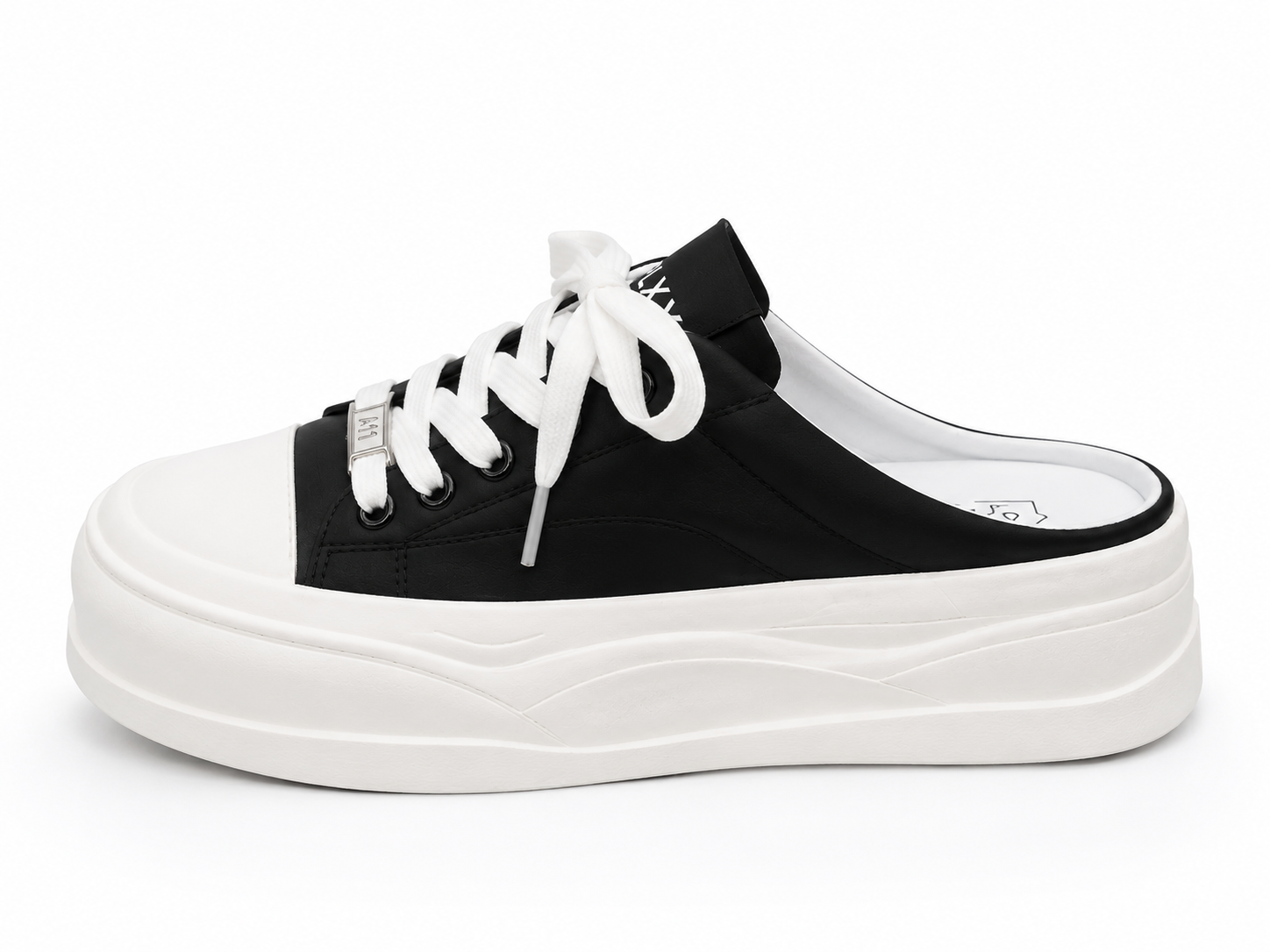 A black canvas slip-on mule sneaker with white laces, a white rubber toe cap, and a thick wavy white platform sole, shown from a side profile on a white background.