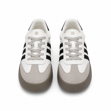 Women's white platform sneakers with black side stripes, gray suede toe cap, thick gray sole, and lace-up design.