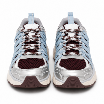 A pair of low-top athletic sneakers shown from the front on a white background. The shoes feature light blue synthetic overlays, a white mesh upper, dark brown knit laces, a metallic silver toe bumper, and a dark brown outsole.