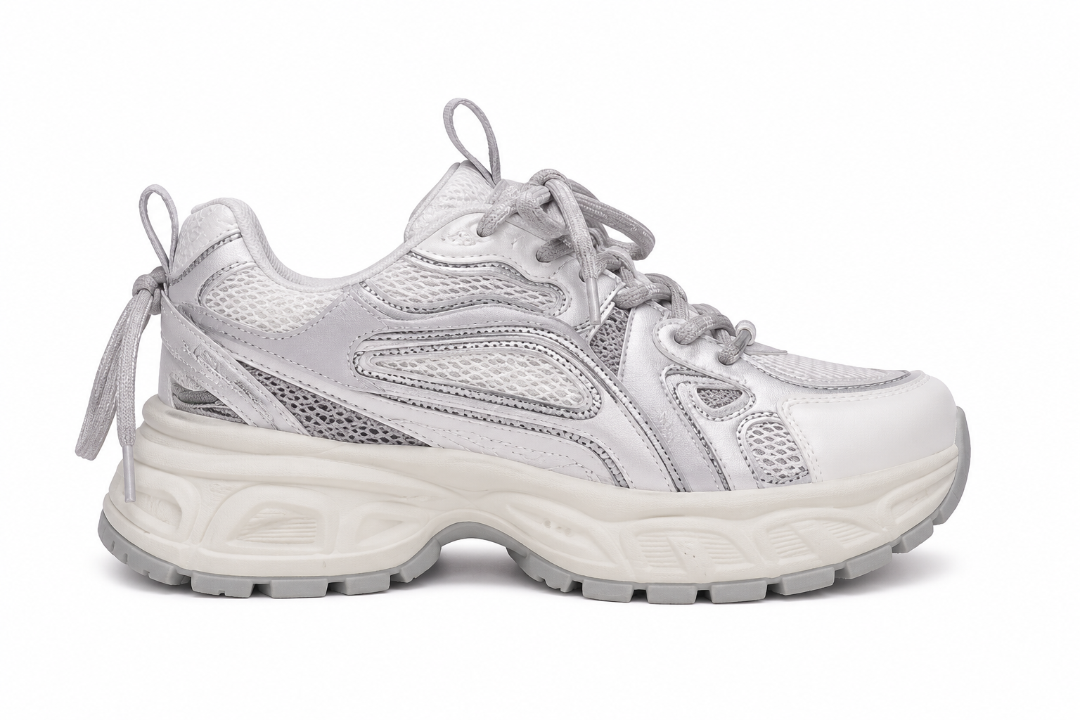 A chunky low-top sneaker in metallic silver and white, featuring a thick textured sole, mesh panels, and metallic side accents, shown from a side profile on a white background.