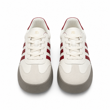 A pair of low-top sneakers shown from a top-down view on a white background. The shoes feature an off-white leather and suede upper with three dark red stripes on the sides, a red lining on the collar, and a thick gray sole.