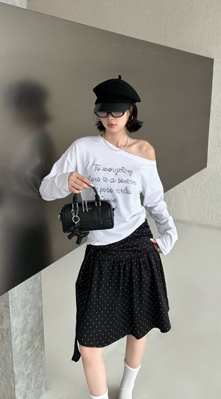 A person modeling carrying a black handbag.